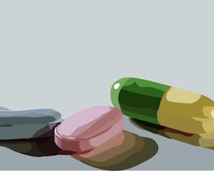 Illustration of a blue pill, a pink pill, and a half-green, half-yellow pill.