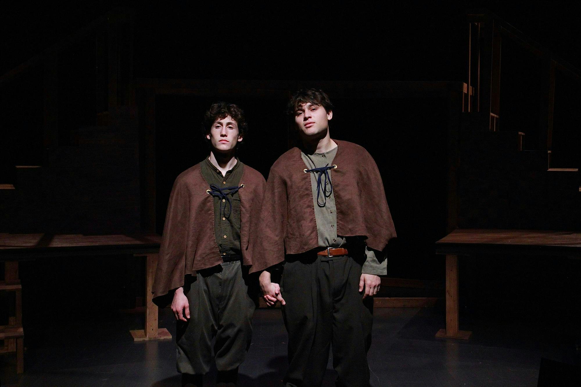 Zane Ellison'28, who plays Rosencrantz, stands on left, and Harry Tarses '27, who plays as Guildenstern, stands on right. The two are holding hands.
