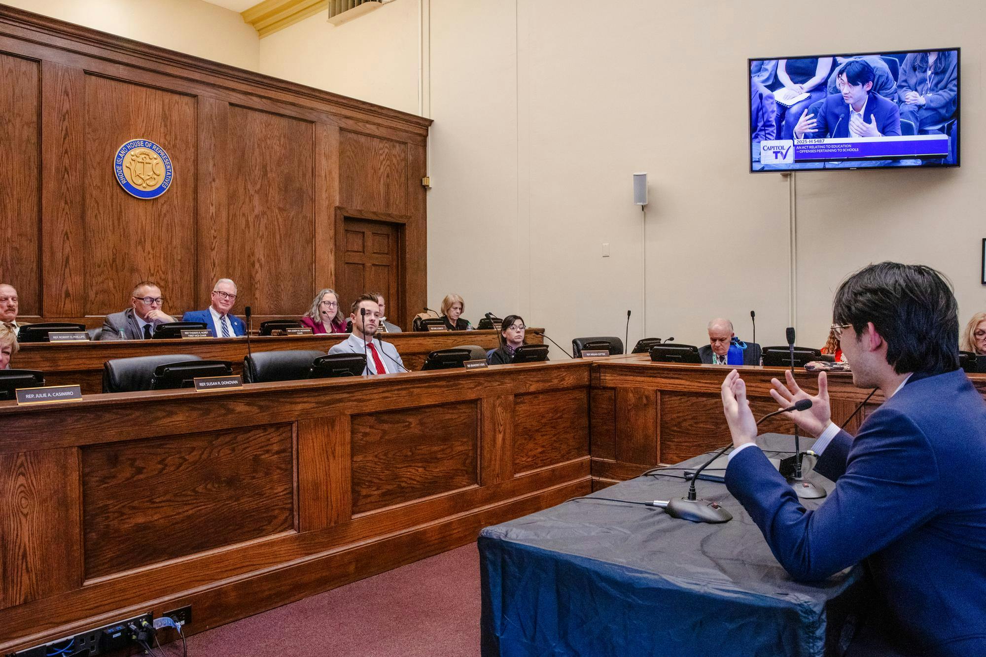 A student testifying in front of a panel at a Rhode Island House Education Committee public hearing.