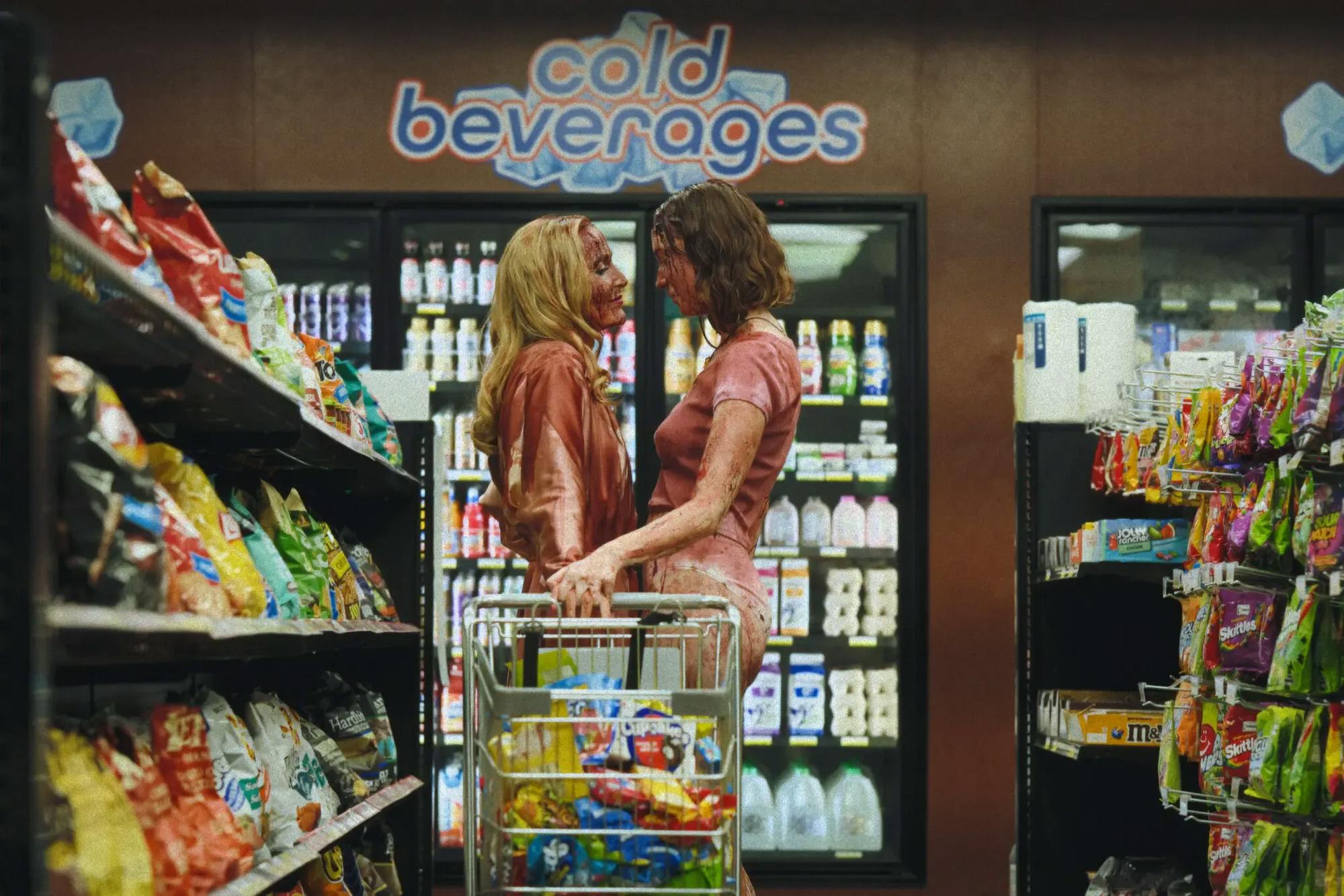 Still from “Teenage Sex and Death at Camp Miasma” showing two women covered in blood looking at each other in a convenience store.