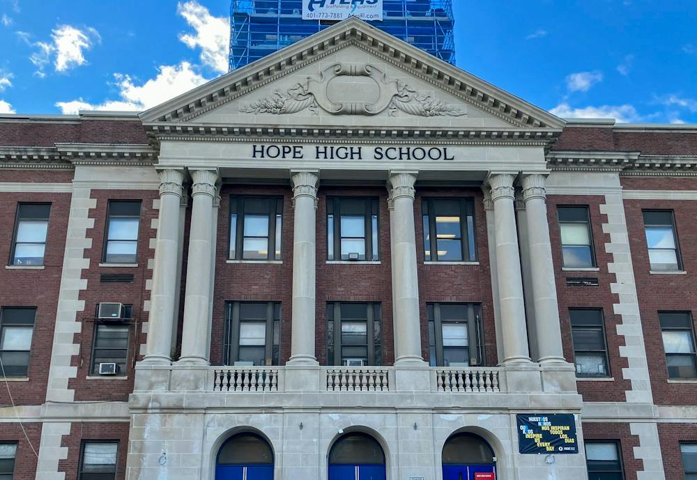 A brick building with large white columns. In black text on the front of the building are the words "Hope High School."