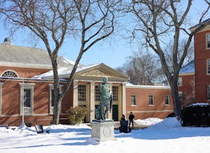 Photo of the Caesar Augustus statue outside the Sharpe Refectory during a sunny day with clear skies and snow on the ground.