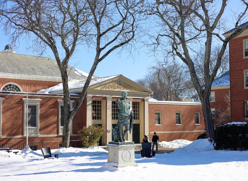 Photo of the Caesar Augustus statue outside the Sharpe Refectory during a sunny day with clear skies and snow on the ground.