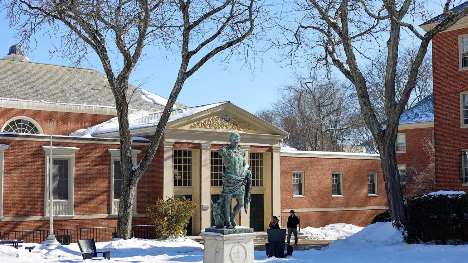 Photo of the Caesar Augustus statue outside the Sharpe Refectory during a sunny day with clear skies and snow on the ground.