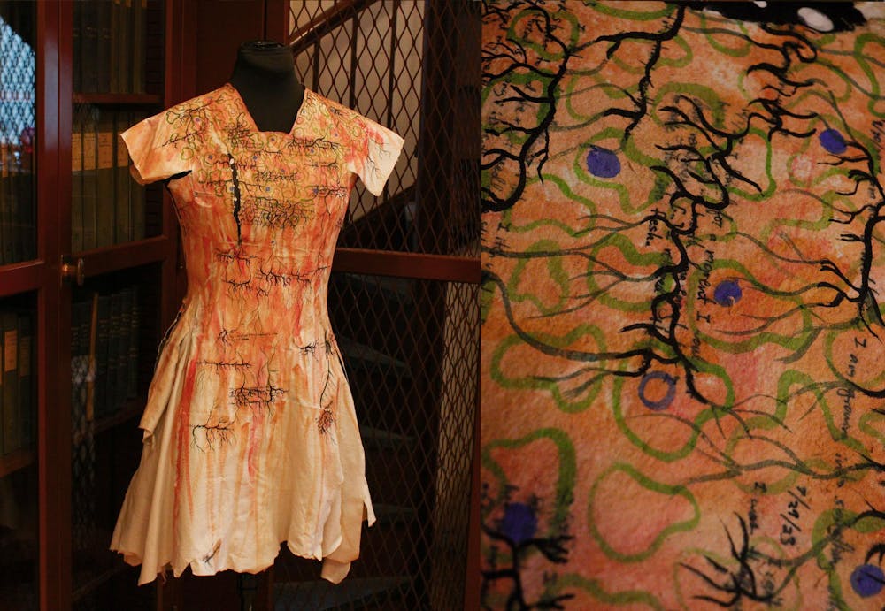 A collage of two photos. The left photo is of an orange cyanotype dress with black, blue, and green illustrations. The right photo shows a closeup of the dress, with the pieces of the sculpture shown to be made of book pages. 