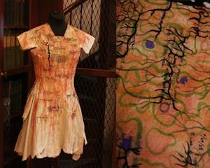 A collage of two photos. The left photo is of an orange cyanotype dress with black, blue, and green illustrations. The right photo shows a closeup of the dress, with the pieces of the sculpture shown to be made of book pages.