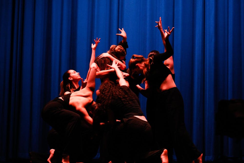 A group of dancers posed with arms and hands in varying positions.