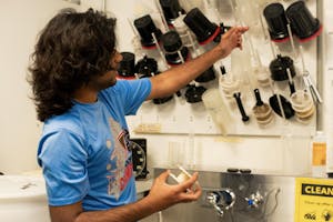 Image of student working in the darkroom in front of the sink.