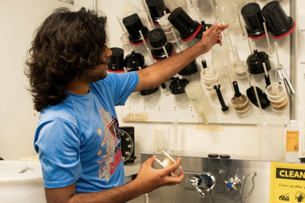 Image of student working in the darkroom in front of the sink.