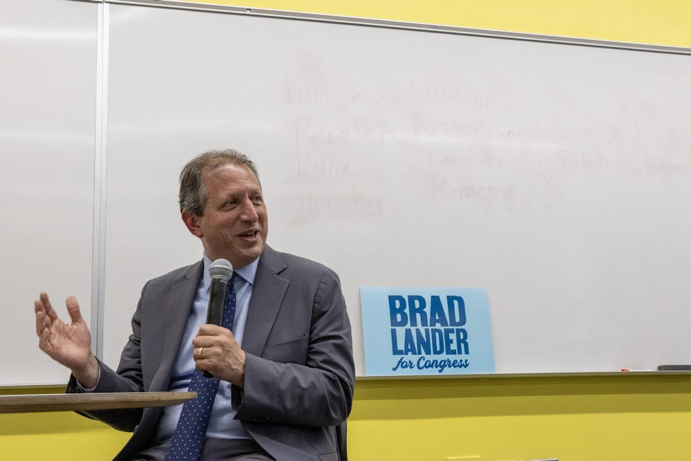 A photo of Brad Lander speaking into a microphone. A sign behind him reads “Brad Lander for Congress.”