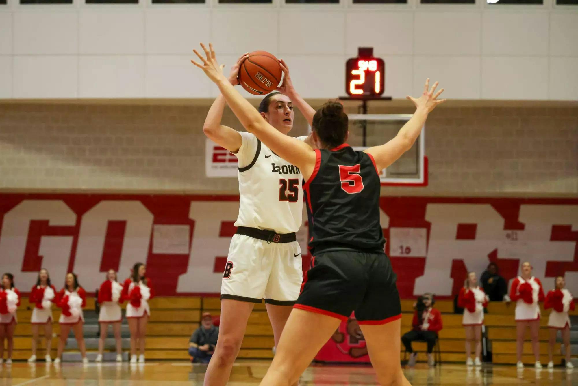 Gianna Aiello '25 holds the ball over her head while guarded by a Cornell defender.