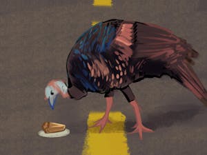 A turkey walking on a road, staring down at a piece of pie sitting in the road.