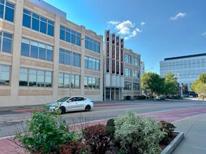 A car is parked alongside the curb in front of the Warren Alpert Medical School of Brown University, located at 222 Richmond Street.