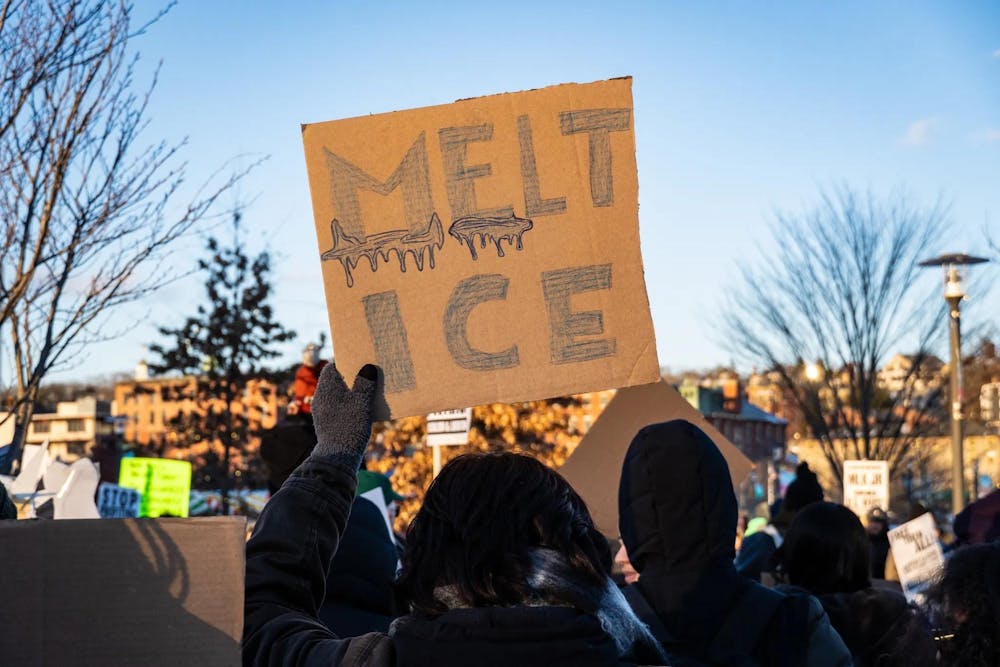 A photo of a cardboard protest sign with the words “Melt Ice” drawn as melted ice. 
