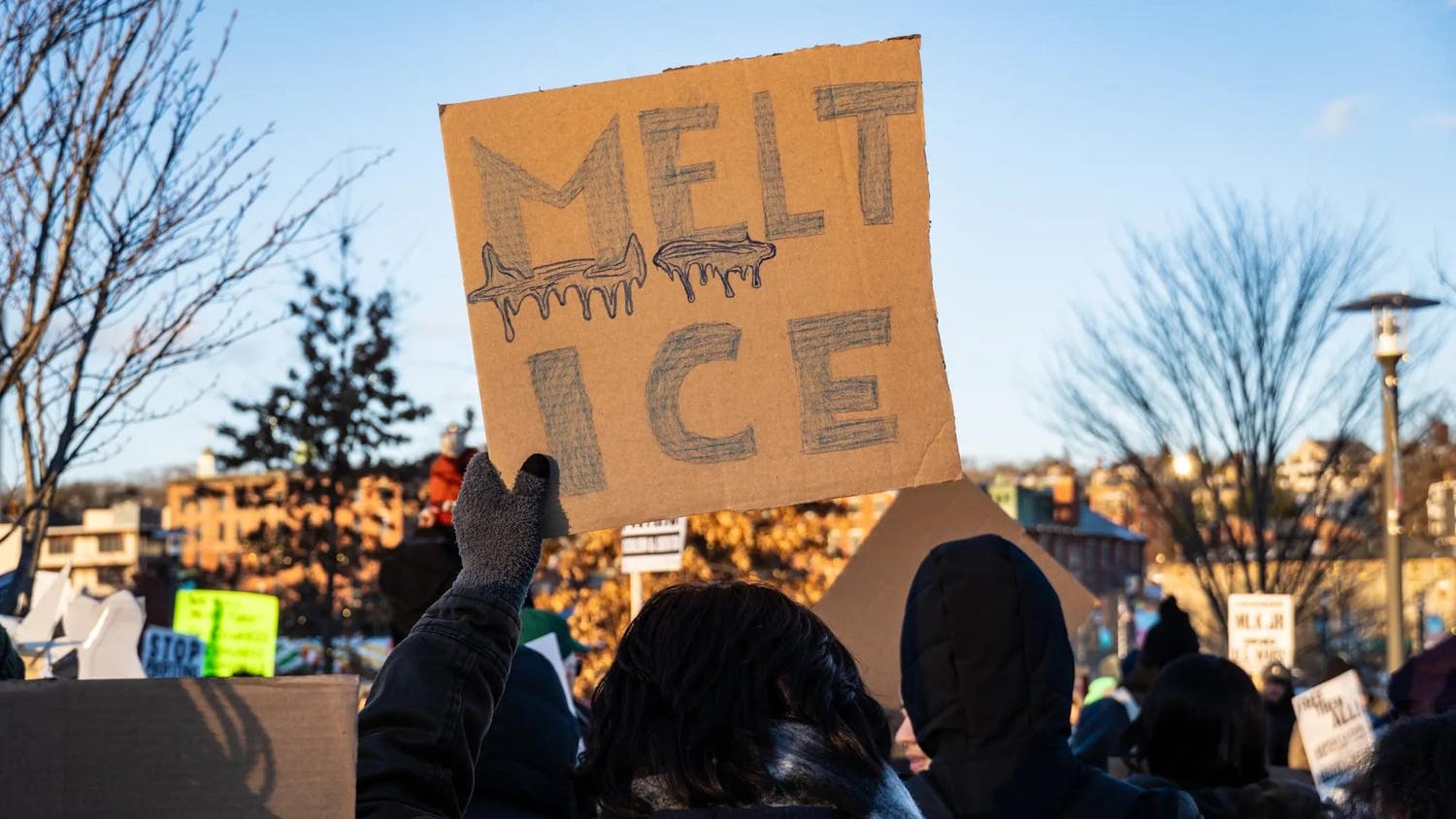 A photo of a cardboard protest sign with the words “Melt Ice” drawn as melted ice.