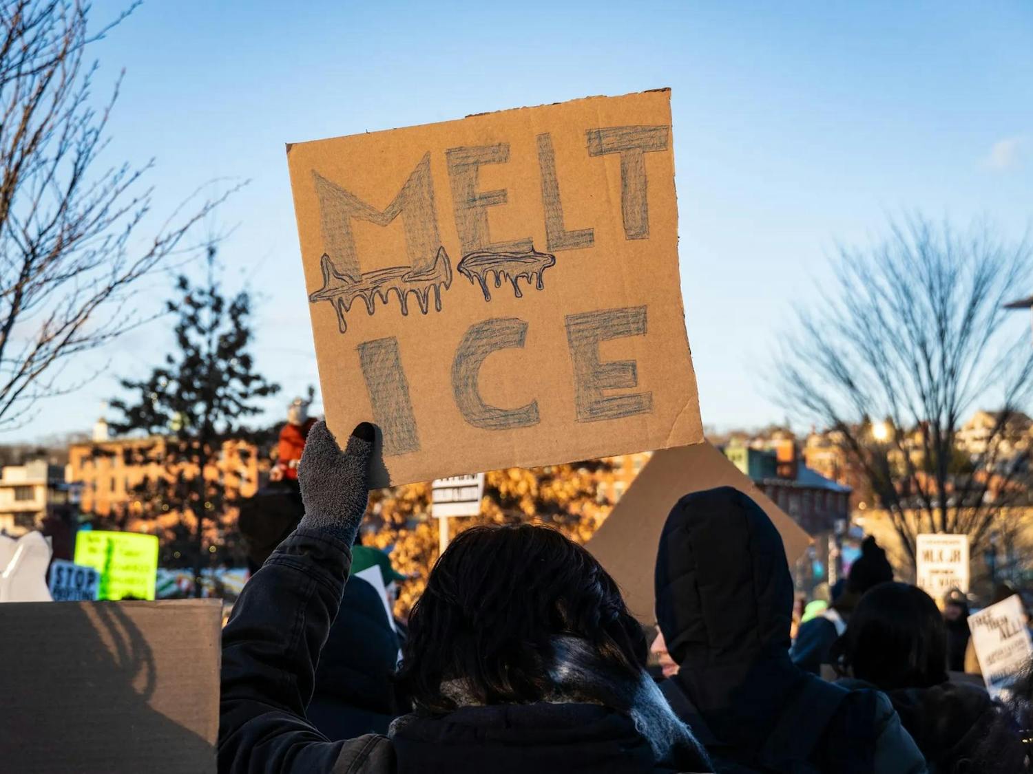 A photo of a cardboard protest sign with the words “Melt Ice” drawn as melted ice.