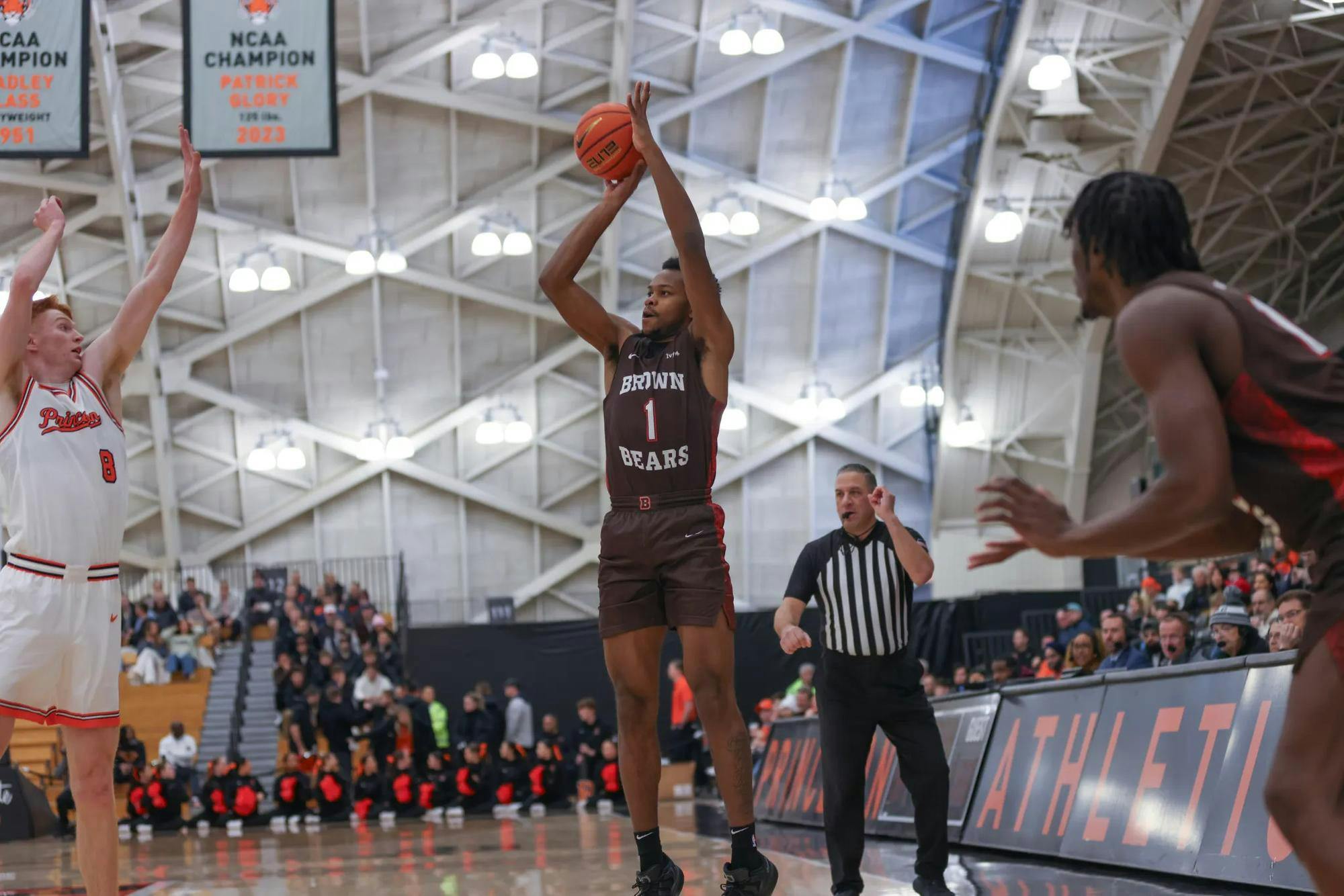 Basketball guard Isaiah Langham ’29 shoots a three-pointer over a Princeton defender.