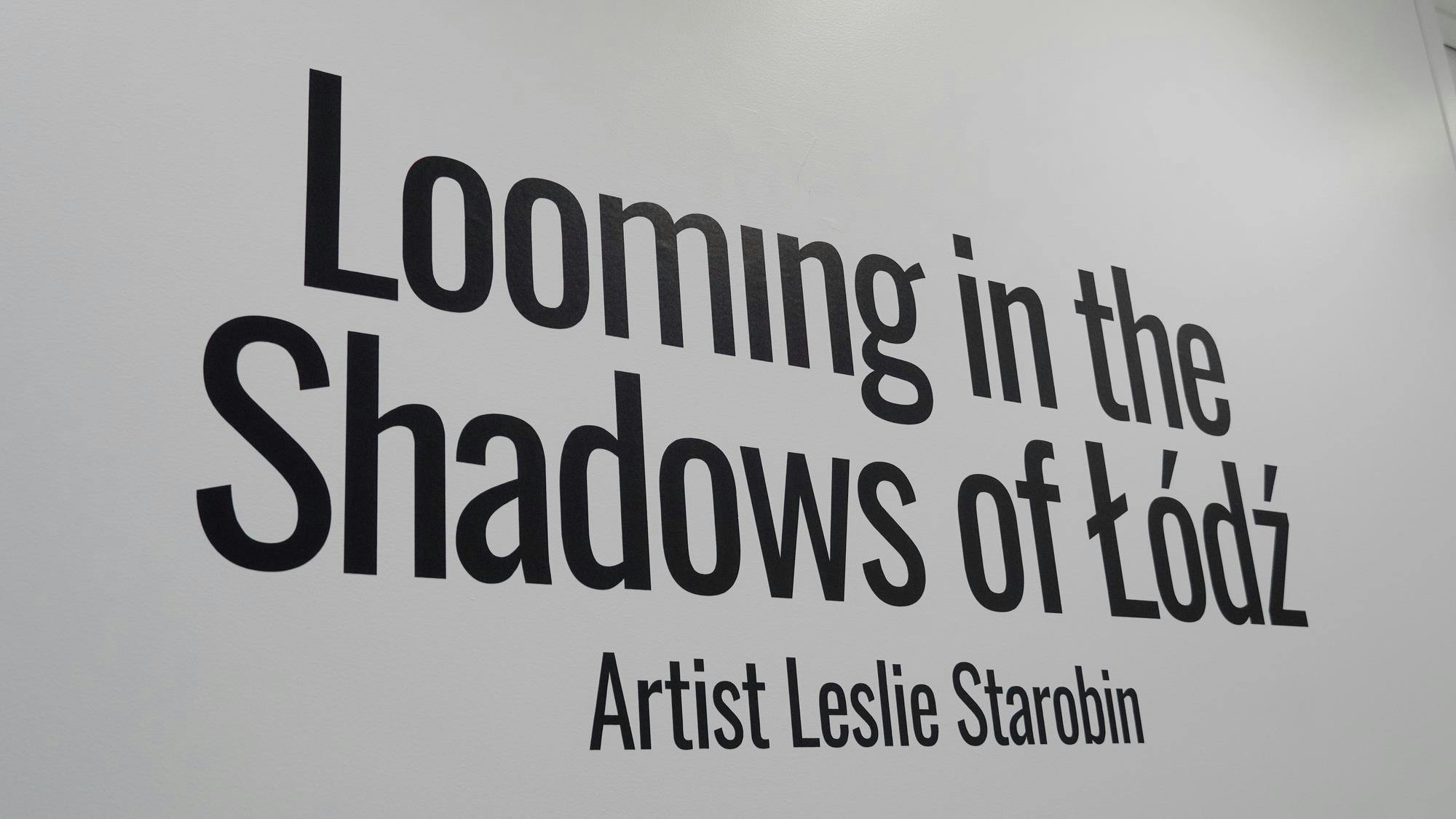 A picture of the exhibit's title reading "Looming in the Shadows of Łódź" with the words "Artist Leslie Starobin" underneath the title.