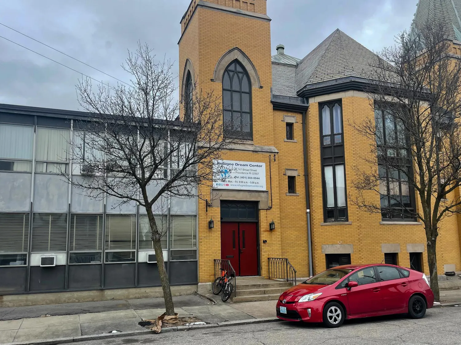 Street view of the refugee dream center, a yellow-bricked building.