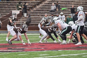 Photo of Brown and Dartmouth football players at the start of a play.