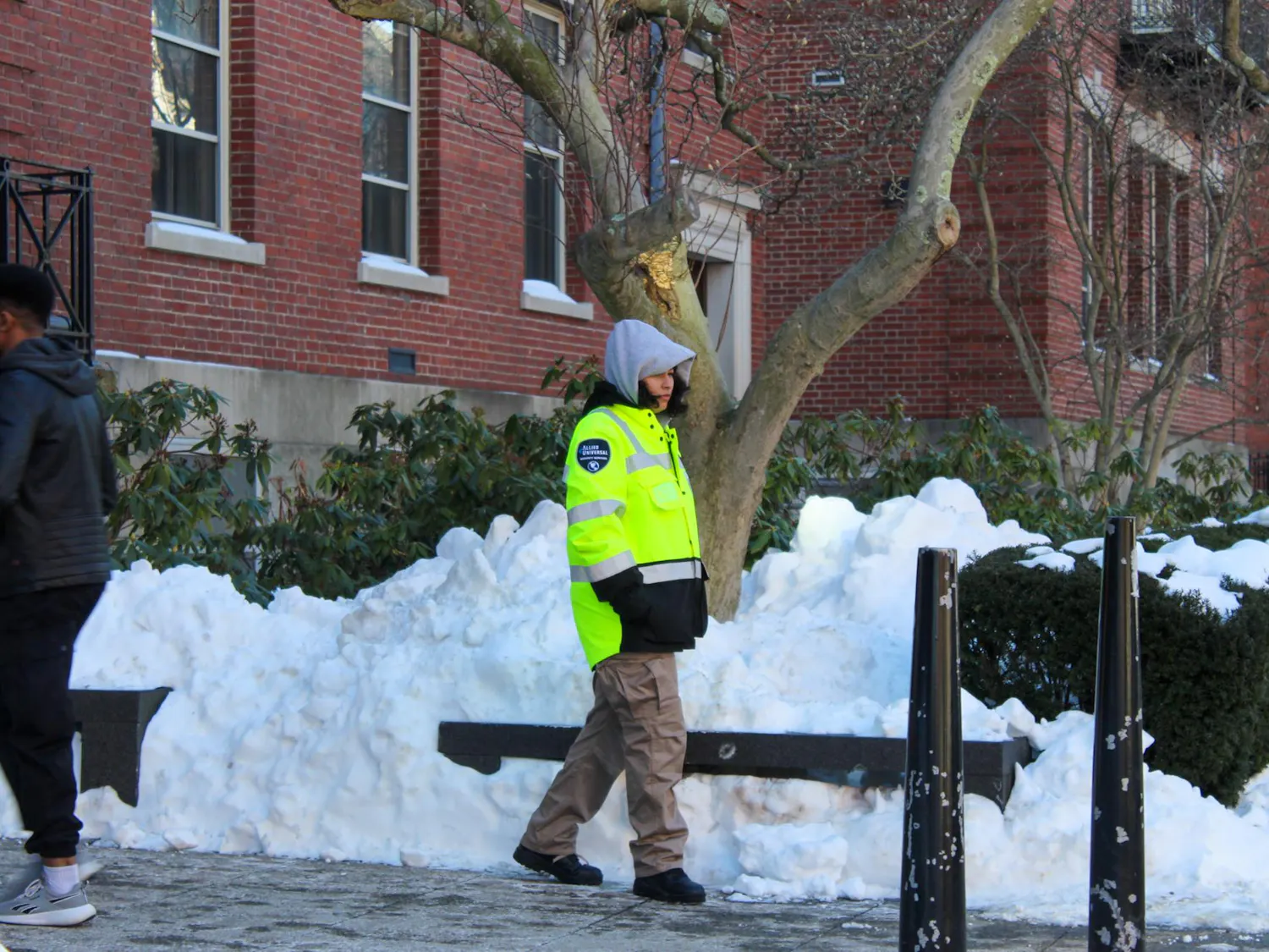 Photo of a security guard walking along a snowy sidewalk.