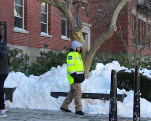 Photo of a security guard walking along a snowy sidewalk.