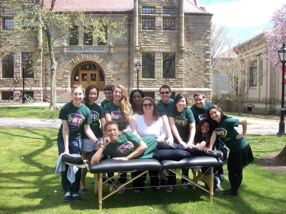 Members of BURP posing with a massage table on the Main Green