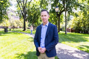 James Kellner stands in a blue suit for a portrait on the Quiet Green.

