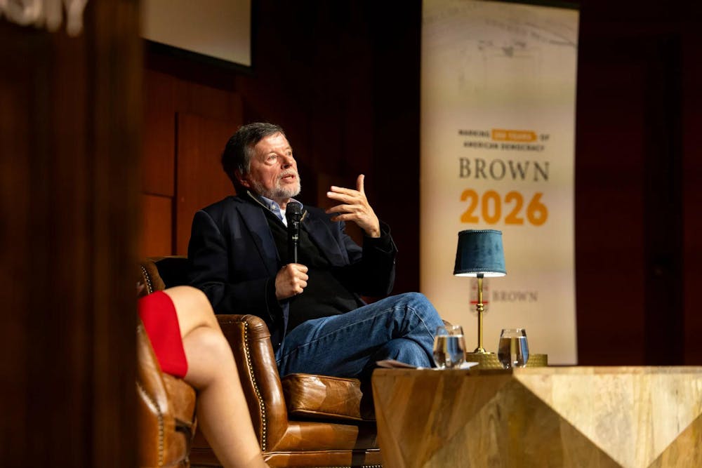 Ken Burns speaks into a microphone facing the audience onstage