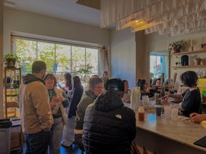 People seated and standing around the crowded coffee bar at Nitro Bar. 