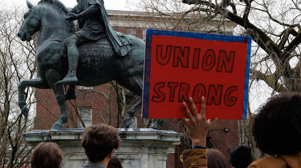 A photo of a hand holding a protest sign with the text “UNION STRONG.”