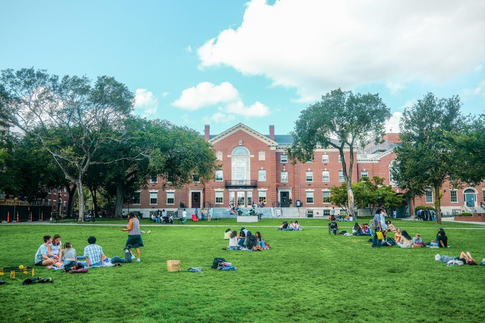 Bright image of students hanging out not he main green in front of the student center.