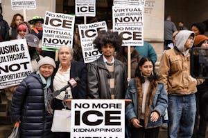 A group of people in front of a podium outside the courthouse. Signs reading "No more ice."