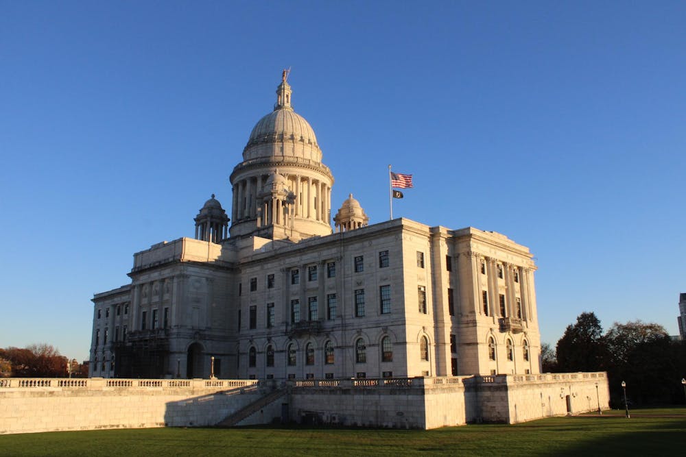 The sunlit State House shot in perspective with an American flag on top.