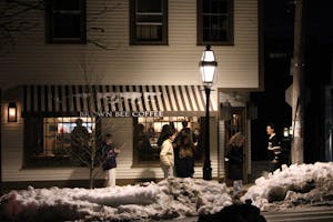 A photo of Brown Bee Coffee, a building with a brown awning, at night in the snow.