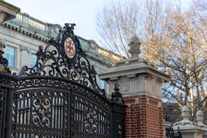 Photo of the top of the Van Wickle Gates against a backdrop of trees and a blue sky.