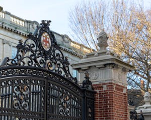 Photo of the top of the Van Wickle Gates against a backdrop of trees and a blue sky.