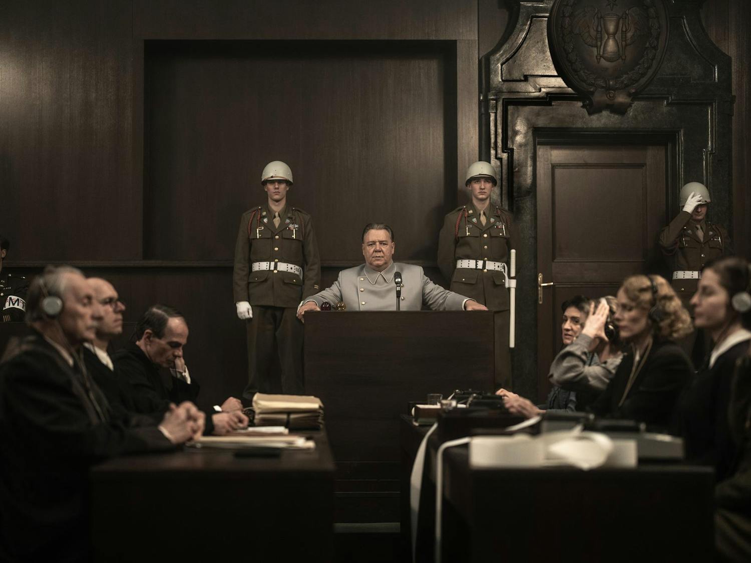 Photo still from the movie Nuremberg showing a man at a podium addressing a room