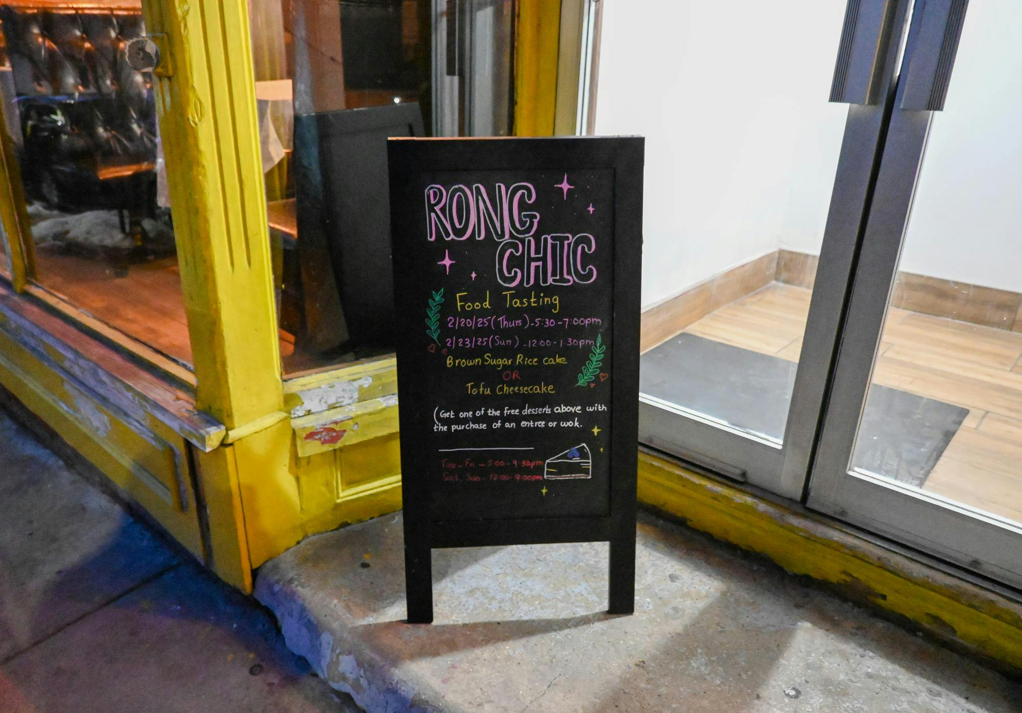 A sign outside of the restaurant with Rong Chic and food tasting written on it.