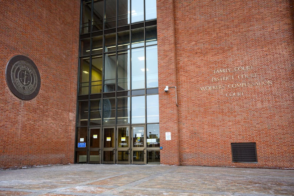A brick building with large glass doors and entrance with "Family Court District Court Workers' Compensation Court" in metal lettering on the right brick wall.