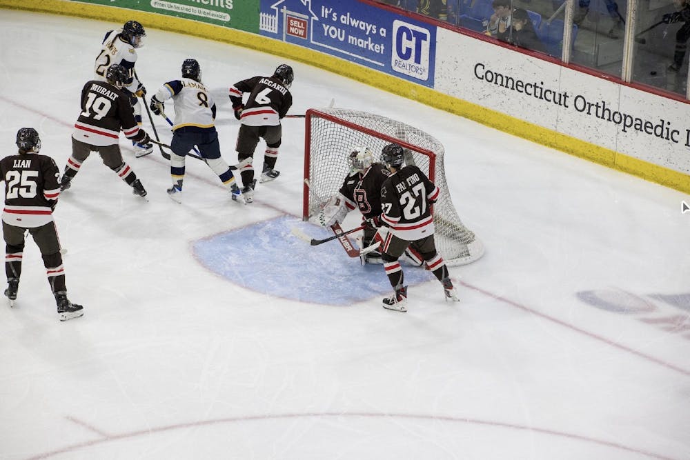 Photo of the Brown women’s hockey team defending their goal against Quinnipiac. 