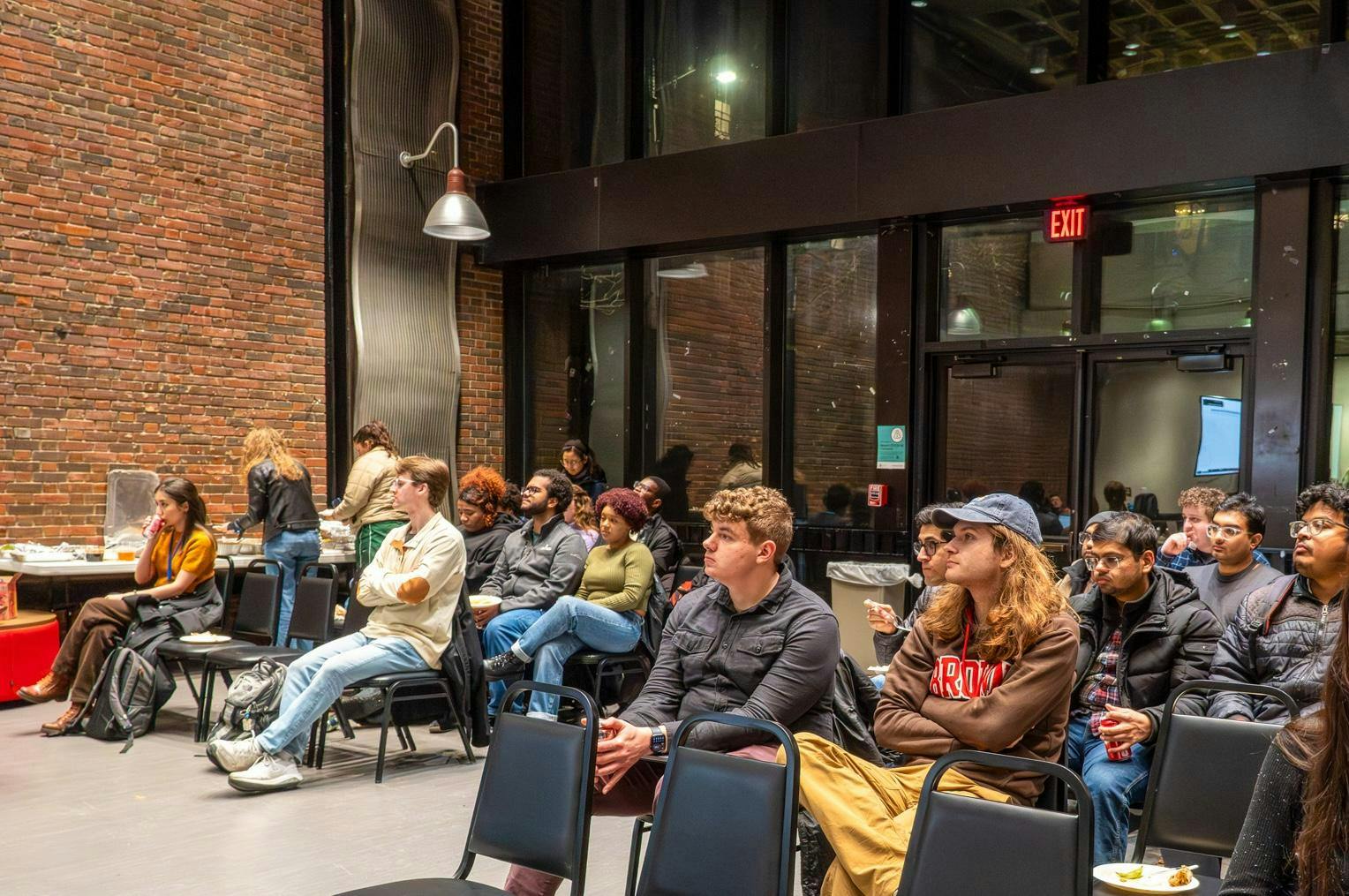 Photo of the GSC meeting where a crowd of students look up at the speaker.