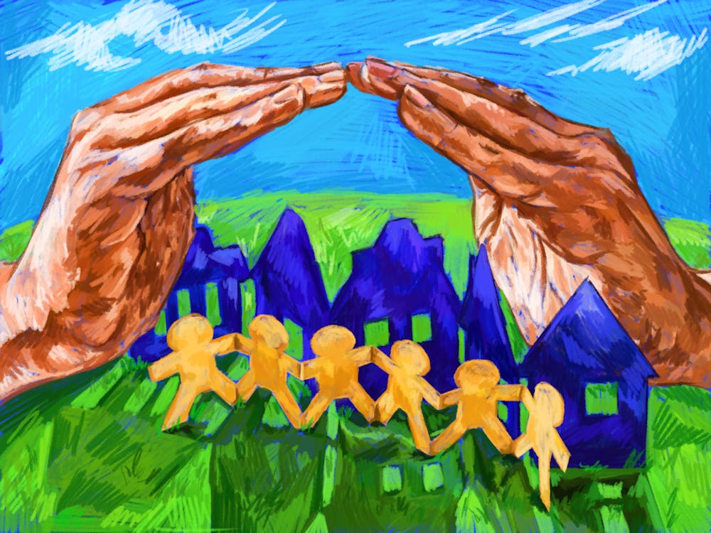 An illustration showing hands shielding a chain of paper houses and paper dolls on a grassy hill on a sunny day. 