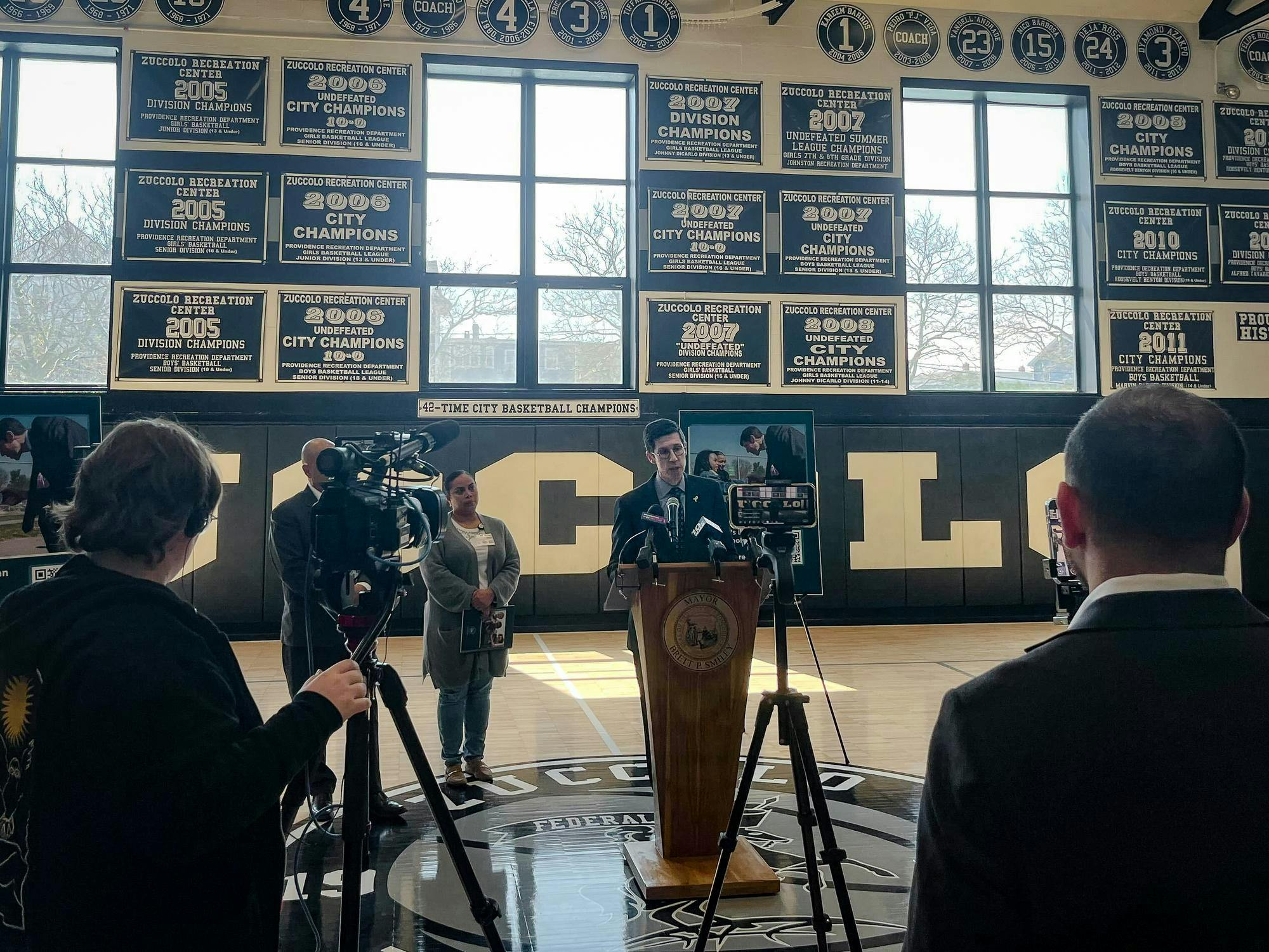 A photo of Mayor Brett Smiley behind a cluster of microphone.