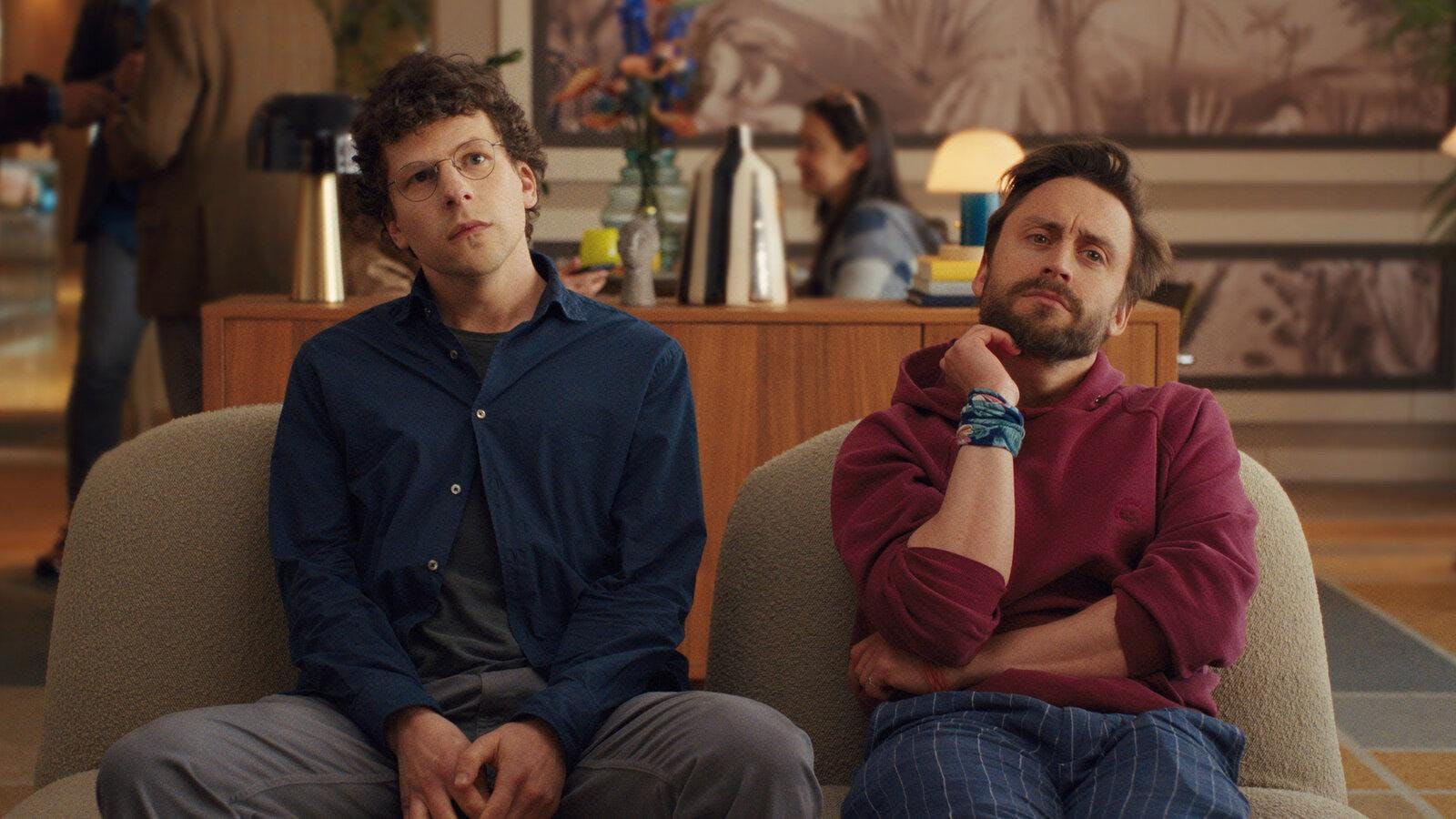 Jesse Eisenberg, left, and Kieran Culkin sitting on a couch