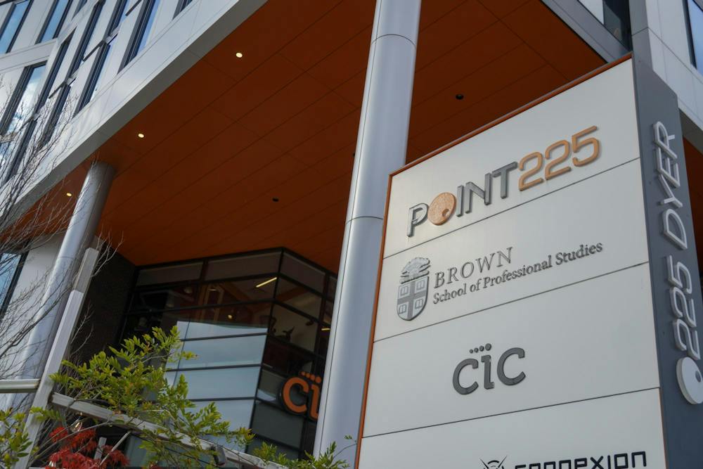 A photo of 225 Dyer Street, a large gray building with orange accents. A sign in the front reads “POINT225,” “Brown School of Professional Studies,” and “CIC.”