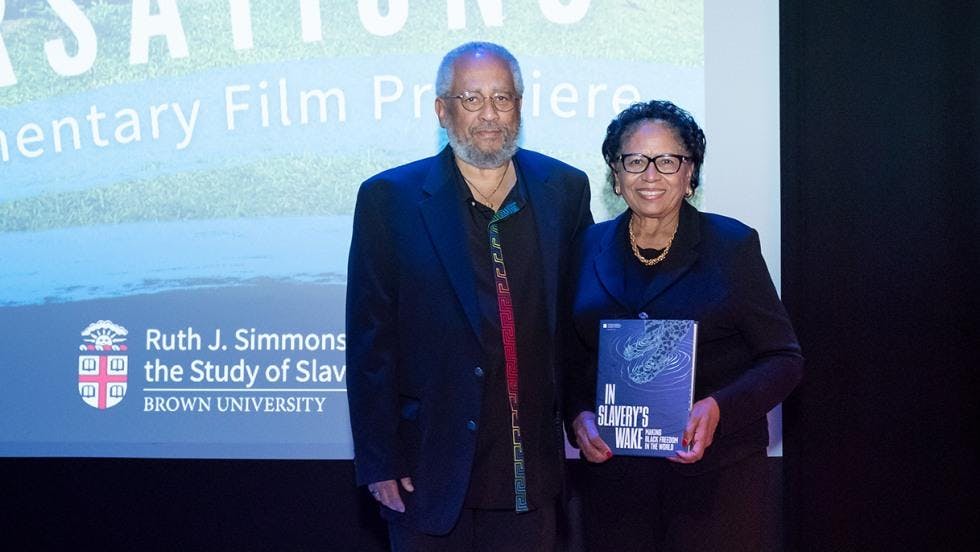 Former University President Ruth J. Simmons and Anthony Bogues, the director of the Simmons Center for the Study of Slavery and Justice, pose for the camera at the exhibition. Simmons is holding an exhibition book titled "In Slavery's Wake."