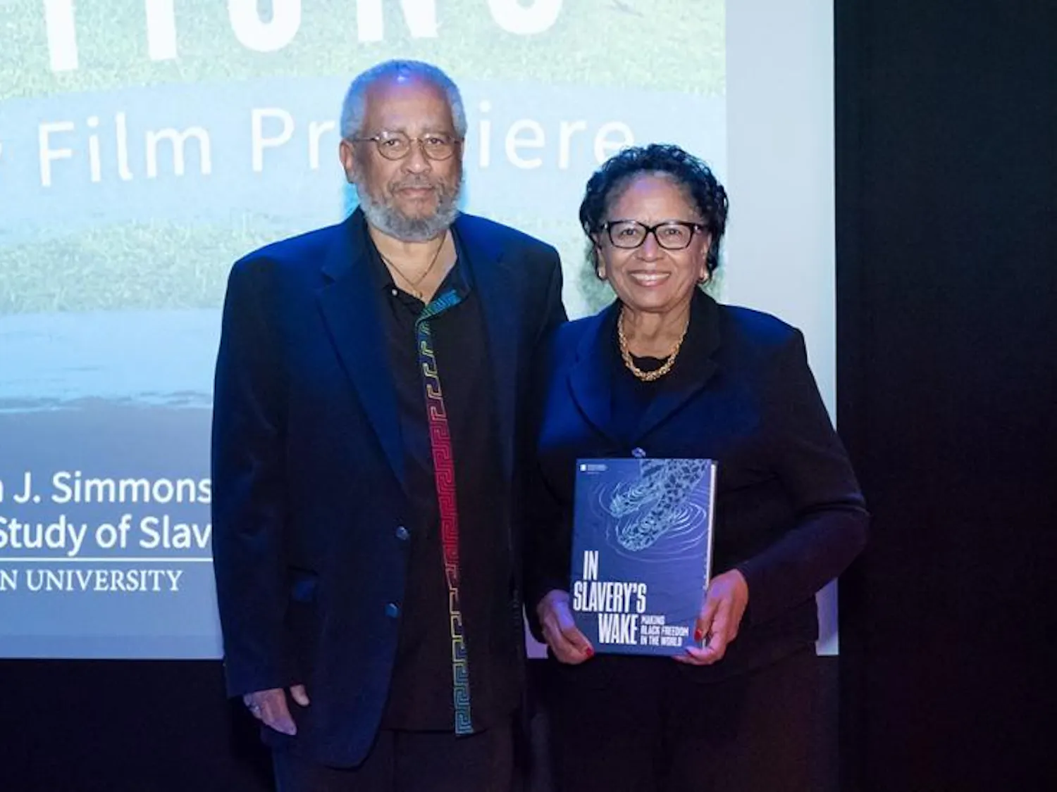 Former University President Ruth J. Simmons and Anthony Bogues, the director of the Simmons Center for the Study of Slavery and Justice, pose for the camera at the exhibition. Simmons is holding an exhibition book titled "In Slavery's Wake."
