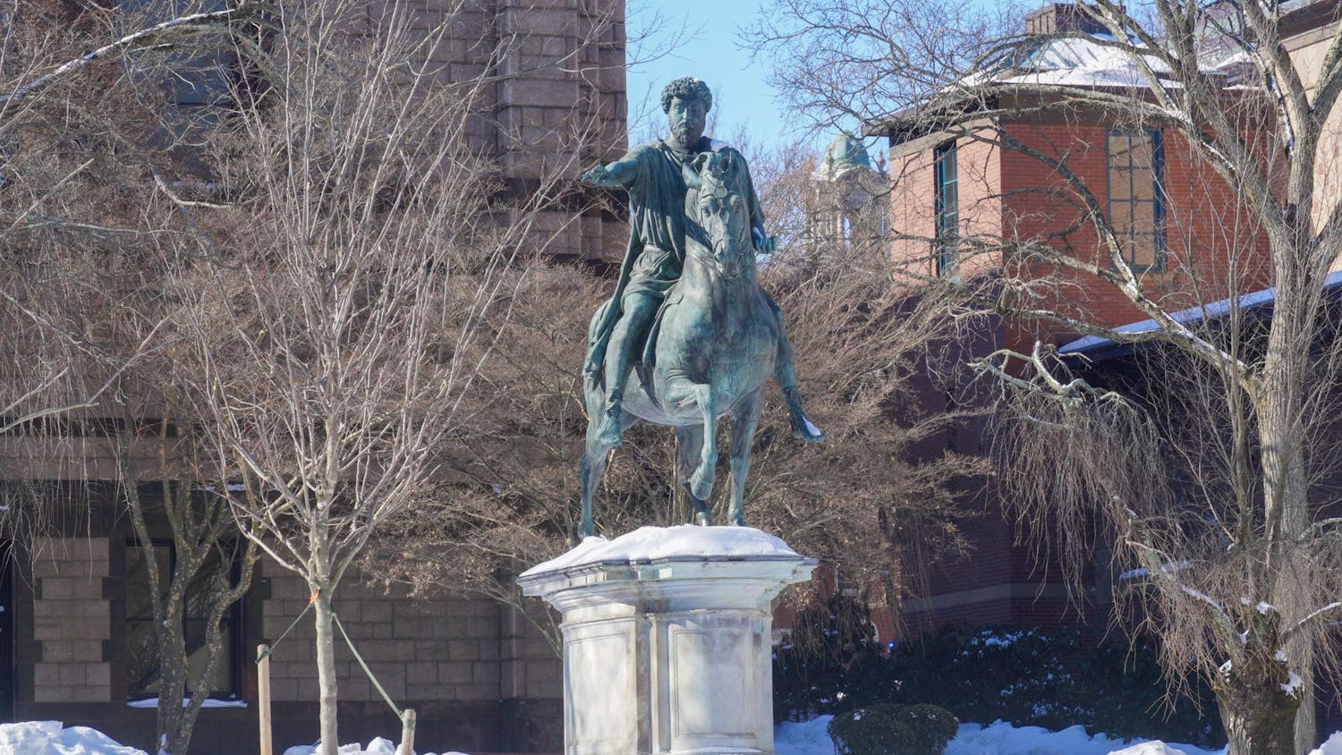 Photo of the Marcus Aurelius statue atop of the hill on Ruth J. Simmons Quadrangle with a layer of snow on the ground.