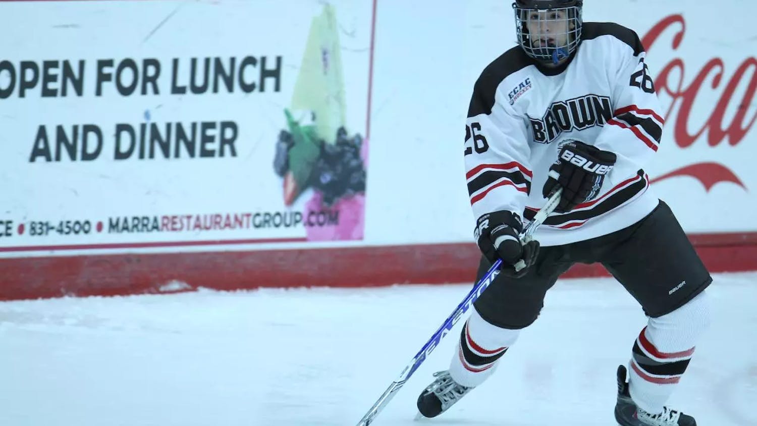 A woman in a hockey uniform skating on ice.